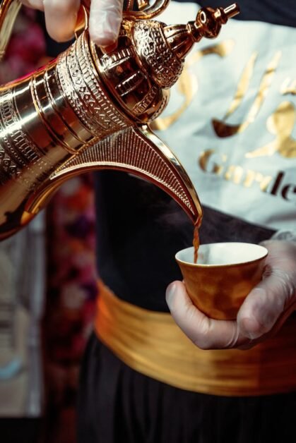 Close-up of authentic Arabian coffee being poured from a traditional pot in Dubai, showcasing cultural heritage.
